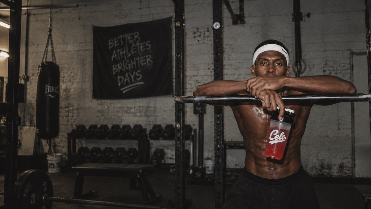 A Celo athlete resting on a pull-up bar after training